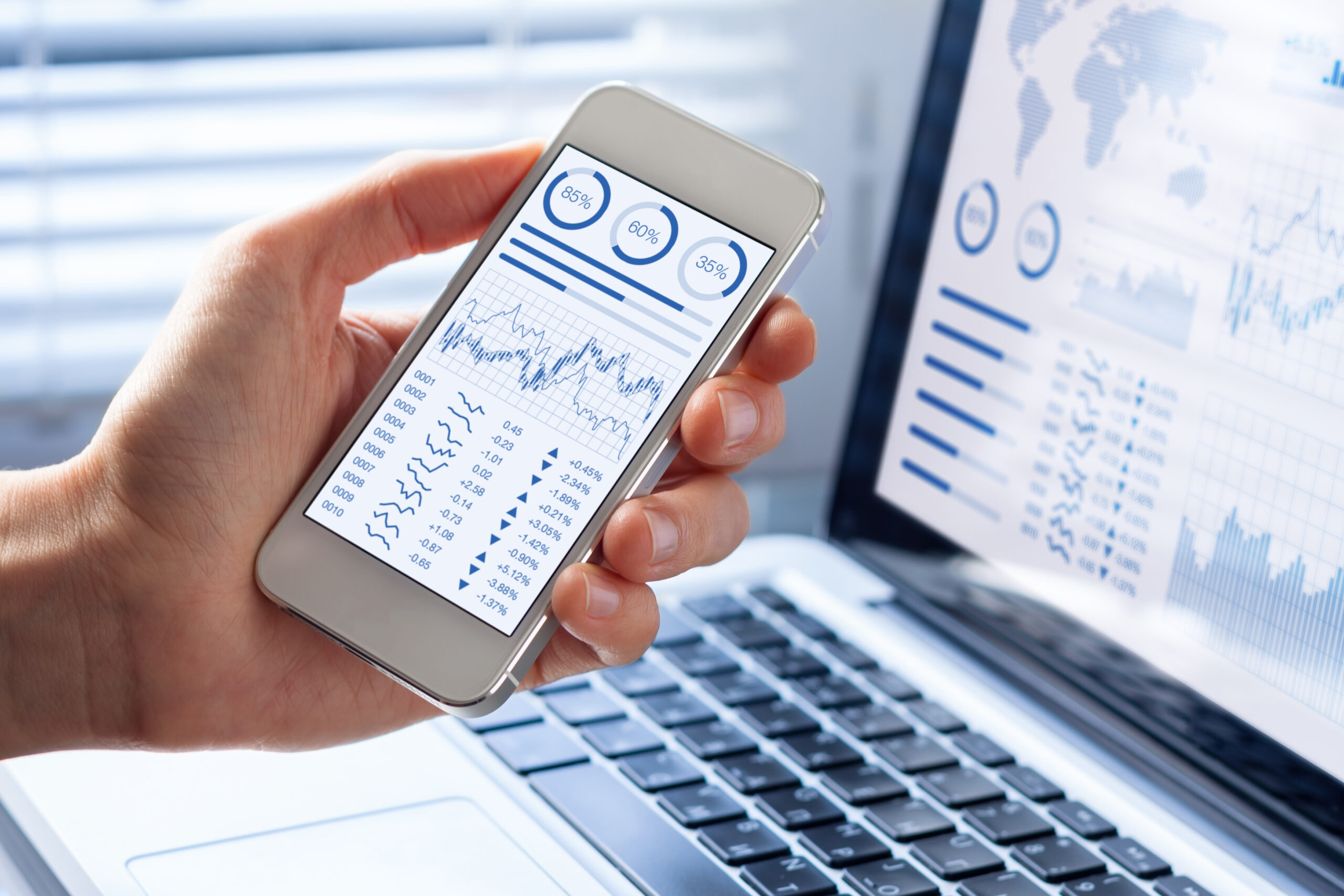 Investor analyzing financial charts on a mobile device, illustrating capital and tax planning decisions for foreign-invested companies in Vietnam